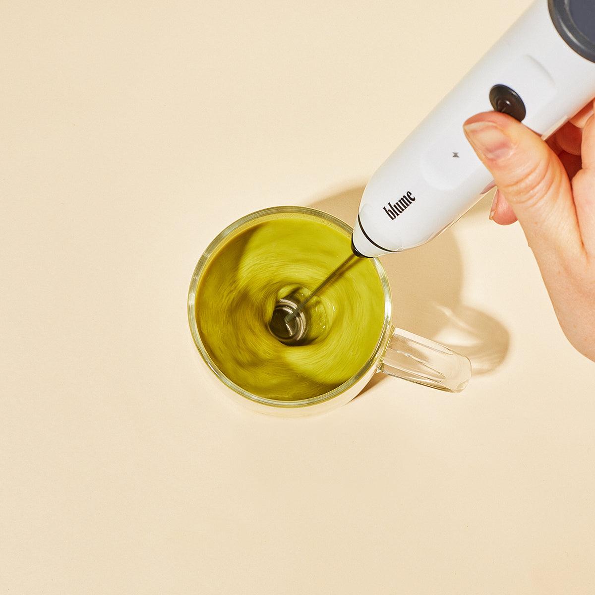 Our white blume frother being used to mix our matcha coconut superfood latte