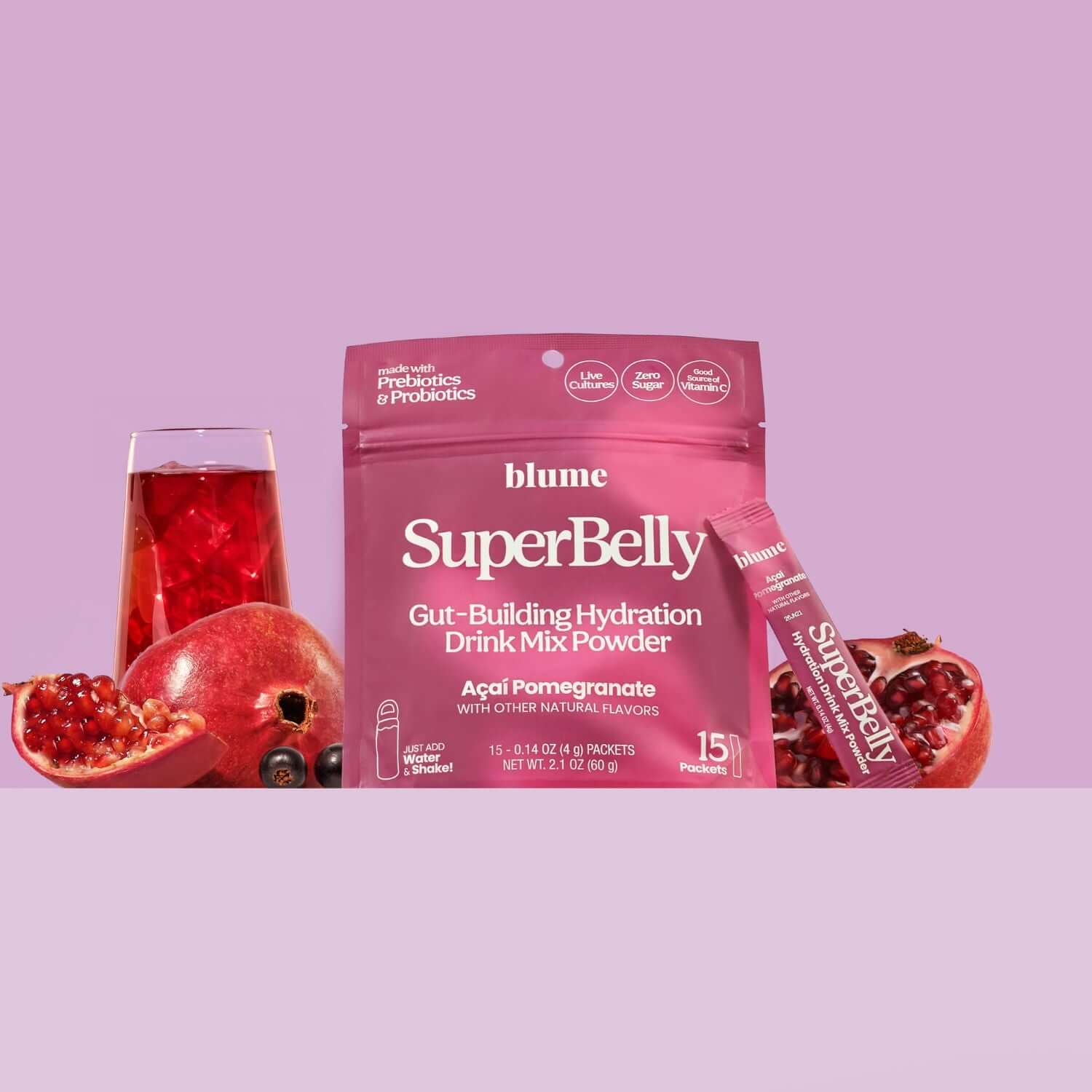 Blume SuperBelly drink mix package with a glass of red juice and pomegranate fruit on a purple background
