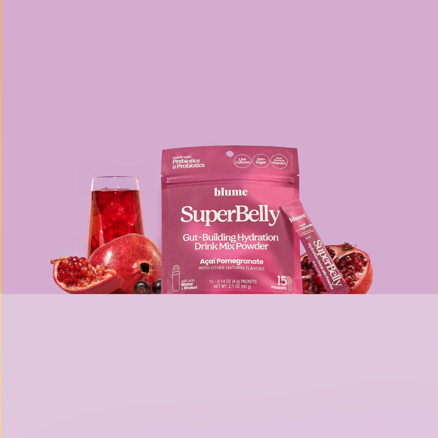 Blume SuperBelly drink mix powder package with a glass of red drink and pomegranate on a light purple background