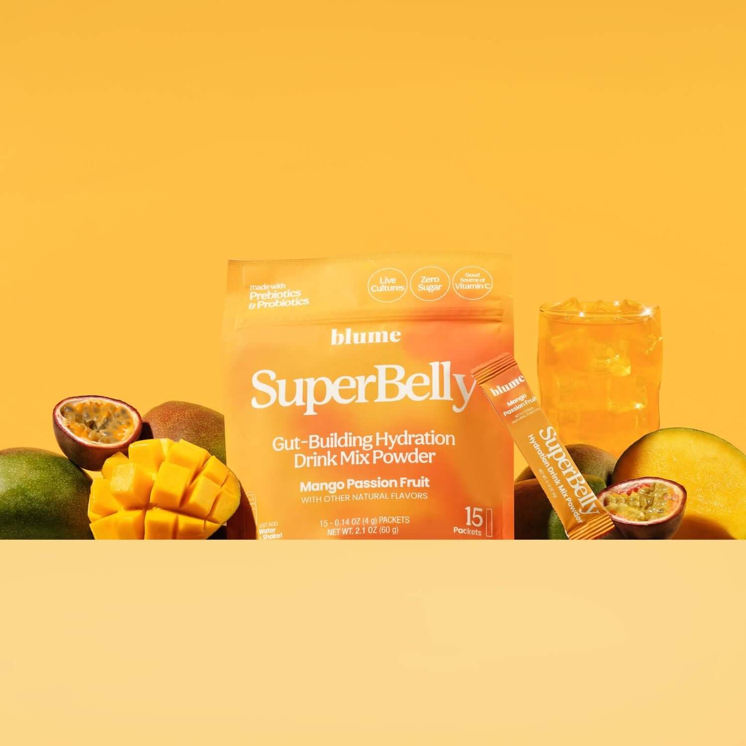 SuperBelly drink mix powder package with mangoes and a glass on a yellow background