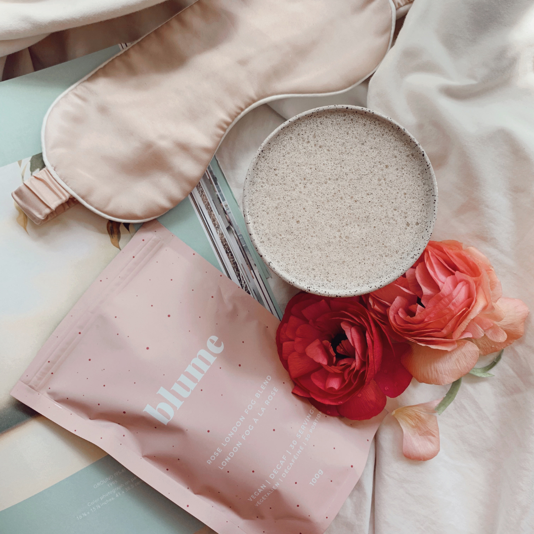 A cup of Blume's Rose London Fog latte with flowers and a pink sleep eye mask taken by @gabrielleassaf