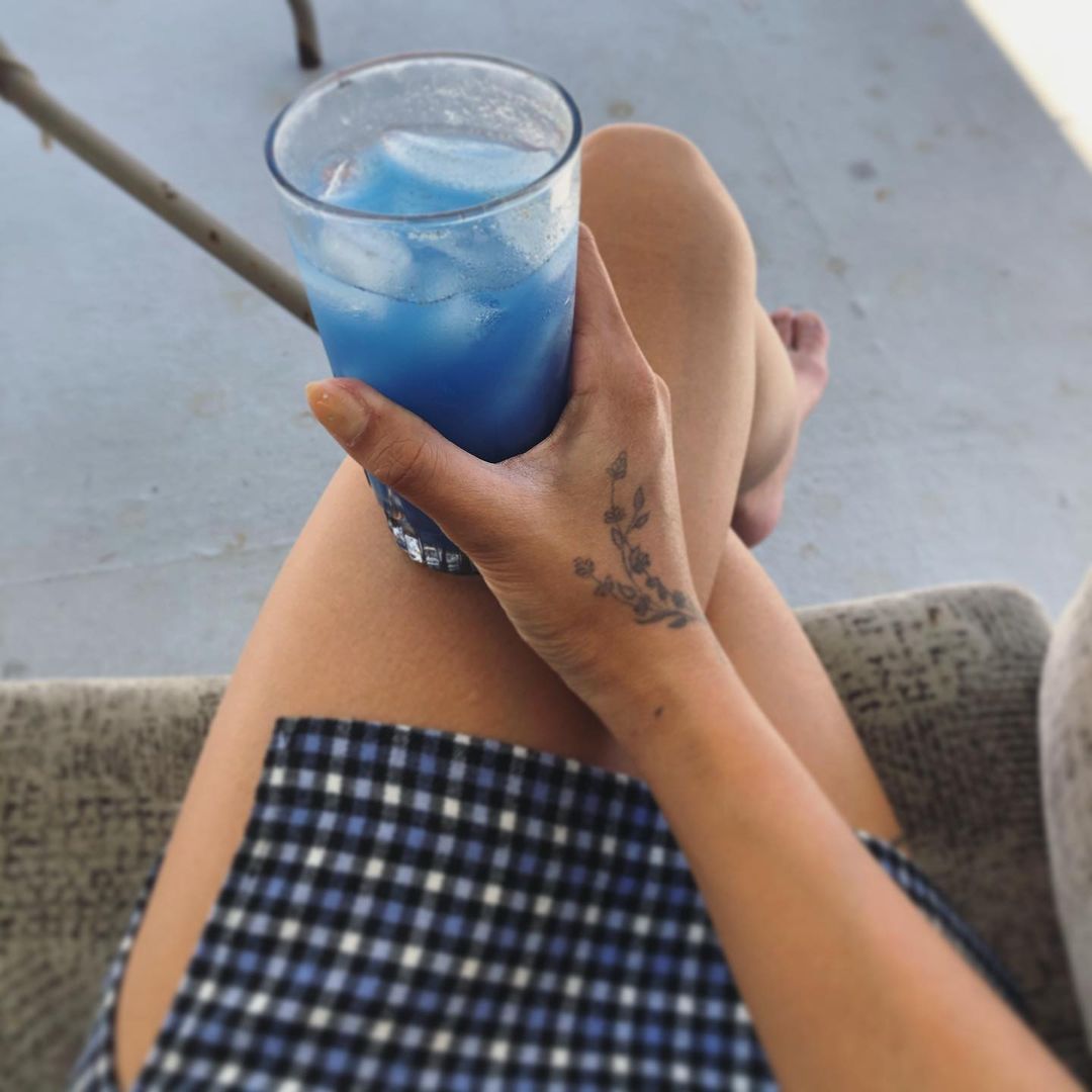 Holding a glass cup of iced Blue Lavender made with Blume's Blue Lavender Blend taken by @phanofeating
